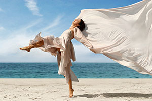   :  happy woman with a scarf on the beach